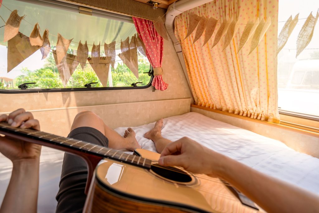 young man traveler laying in camper van and playin 2023 11 27 05 09 05 utc
